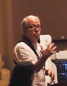 Mark is standing, makes a grand gesture